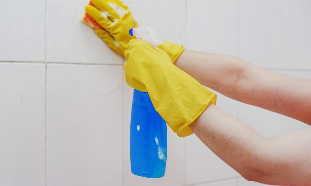 Cleaning bathroom tiles. Women washing bath walls. Housemaid cleaning up tiles of bath. Householding jobs.